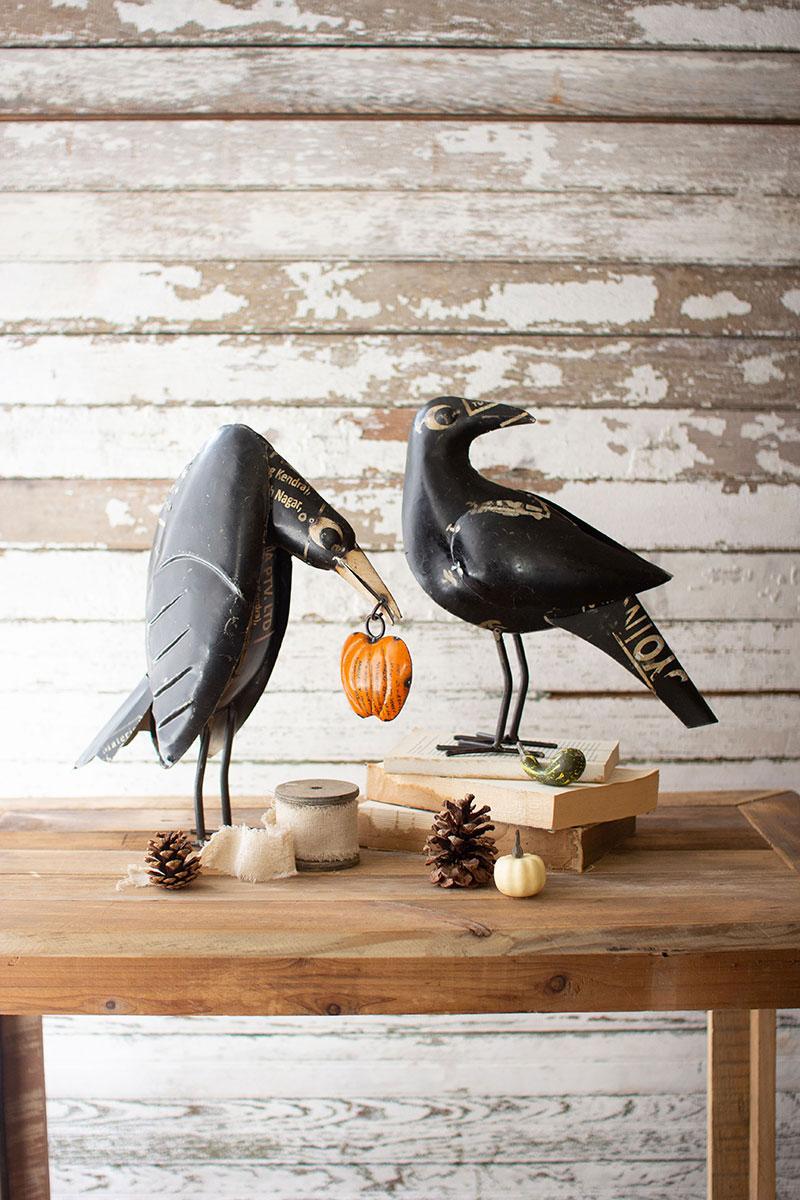 set of two recycled iron crows holding a pumpkin