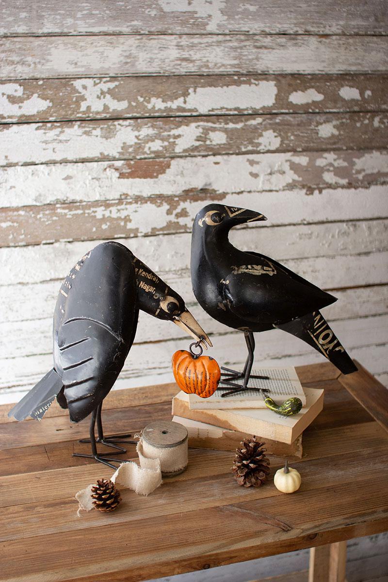 set of two recycled iron crows holding a pumpkin